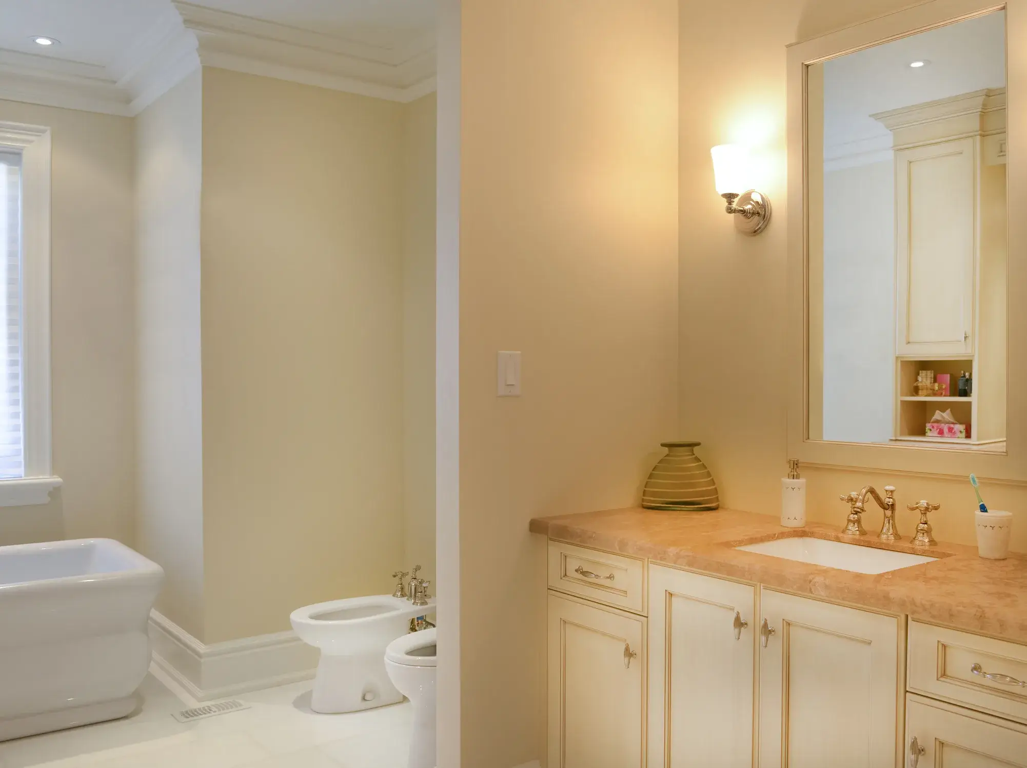 A bathroom with beige painted walls and white trim