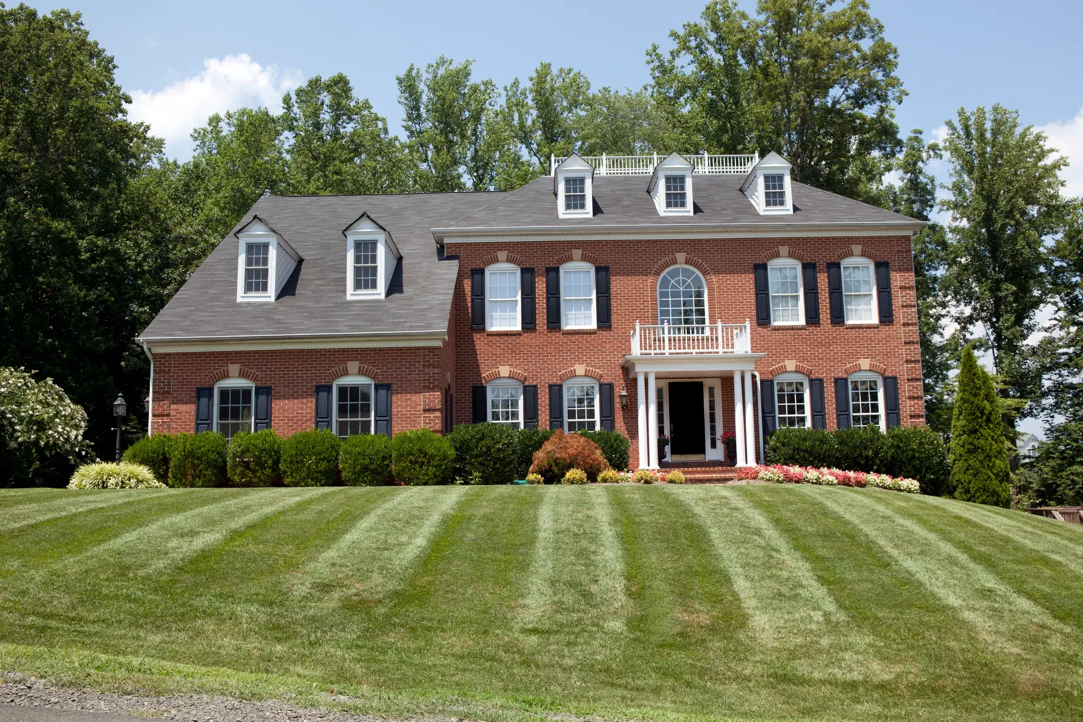 Brick home exterior with white trim and black shutters