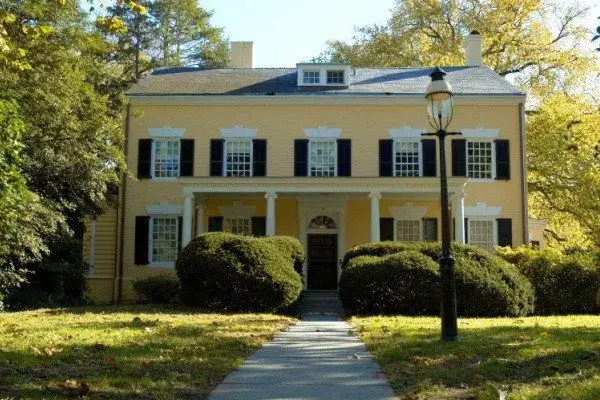 Yellow colonial home in Buckhead with dark shutters and white trim