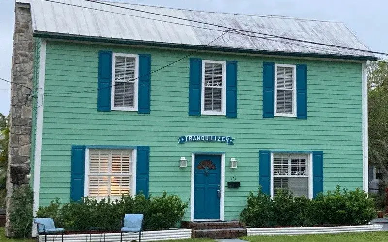 Alpharetta colonial home painted green with a blue door and shutters