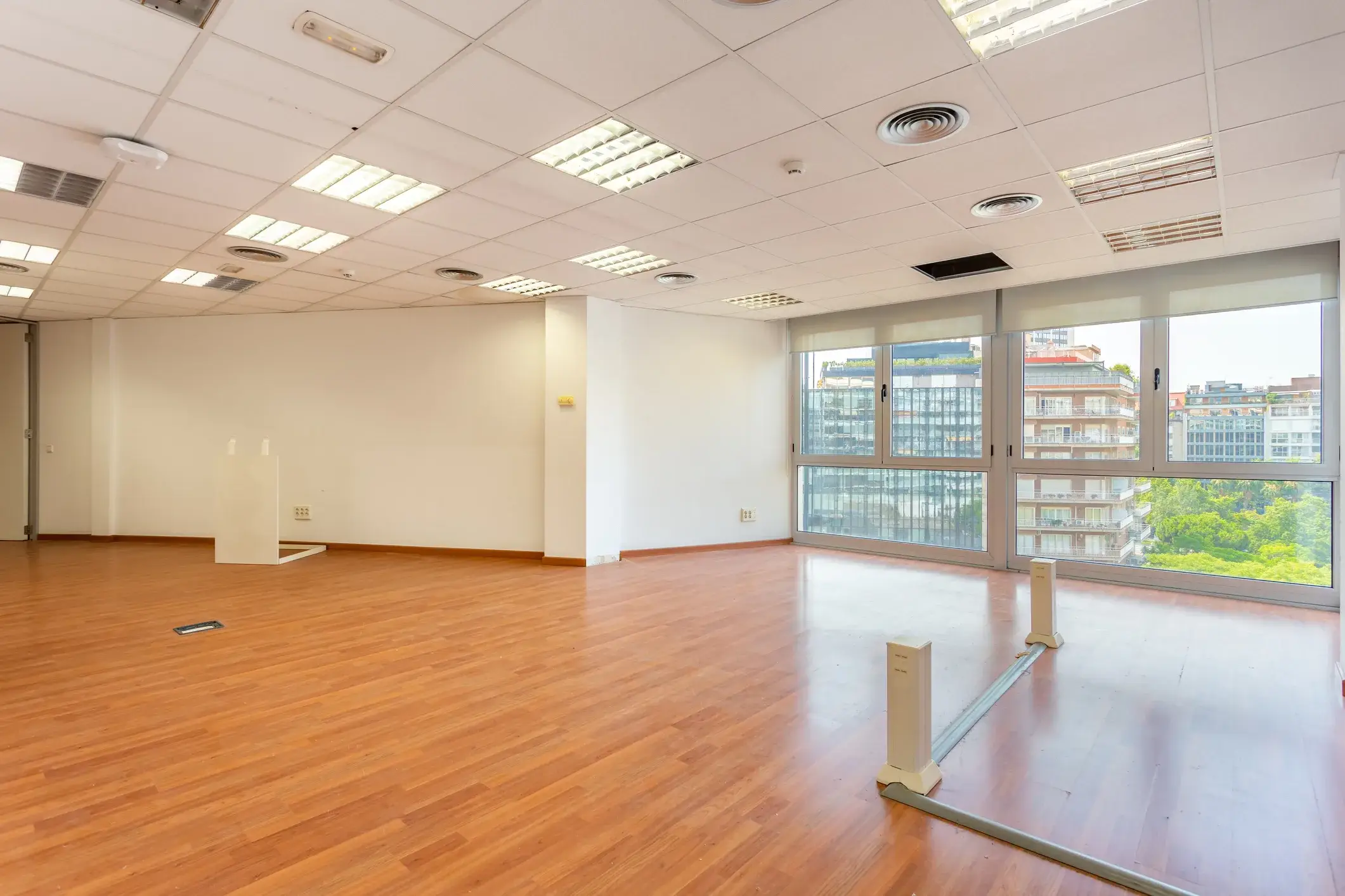 An empty office floor with freshly painted white walls and full-height windows