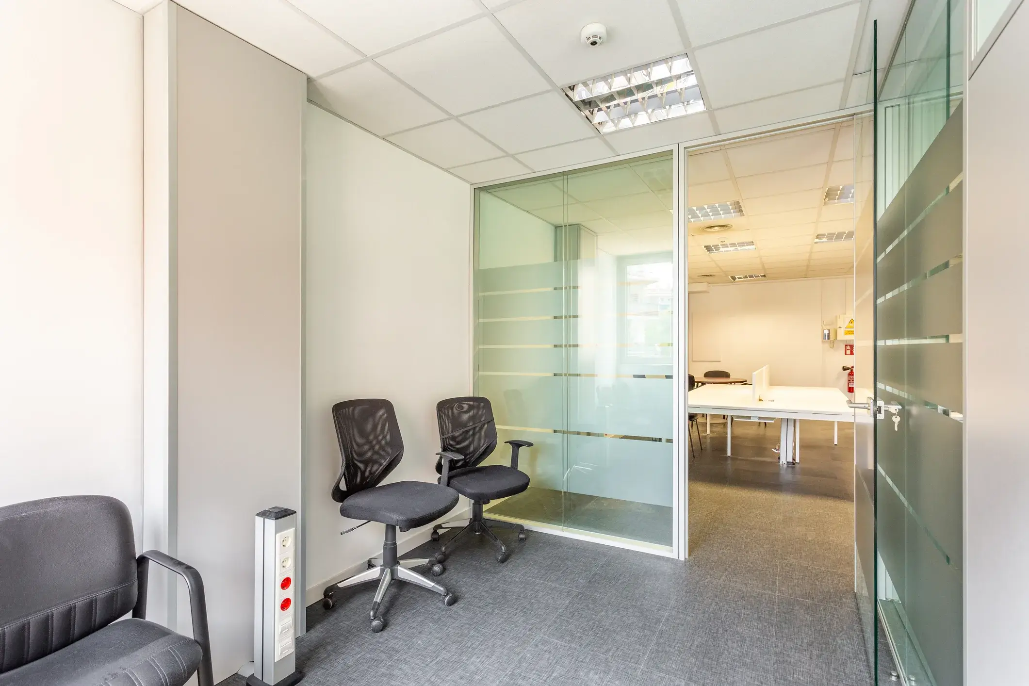 An office waiting area with painted walls and glass partitions