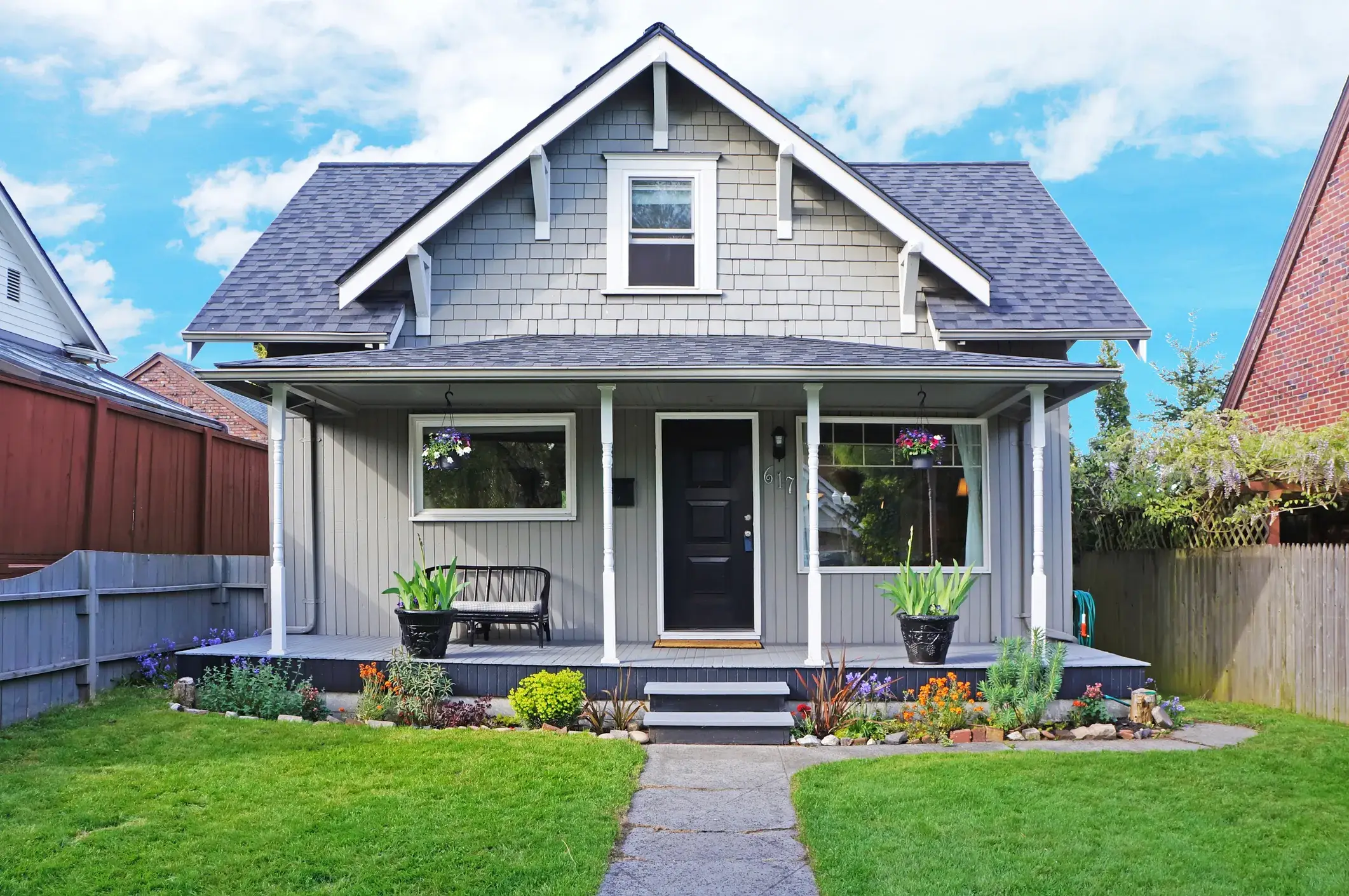 Blue home exterior with a red front door and white porch columns