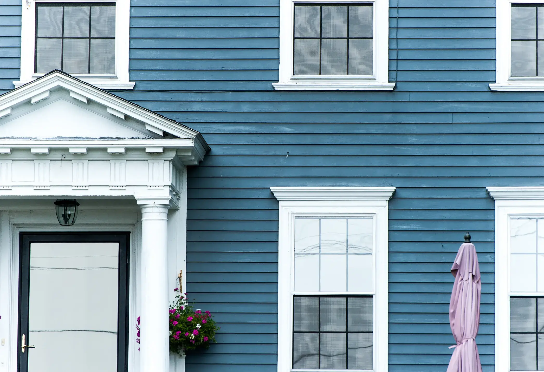 Colonial home exterior painting, blue body with black shutters and white trim