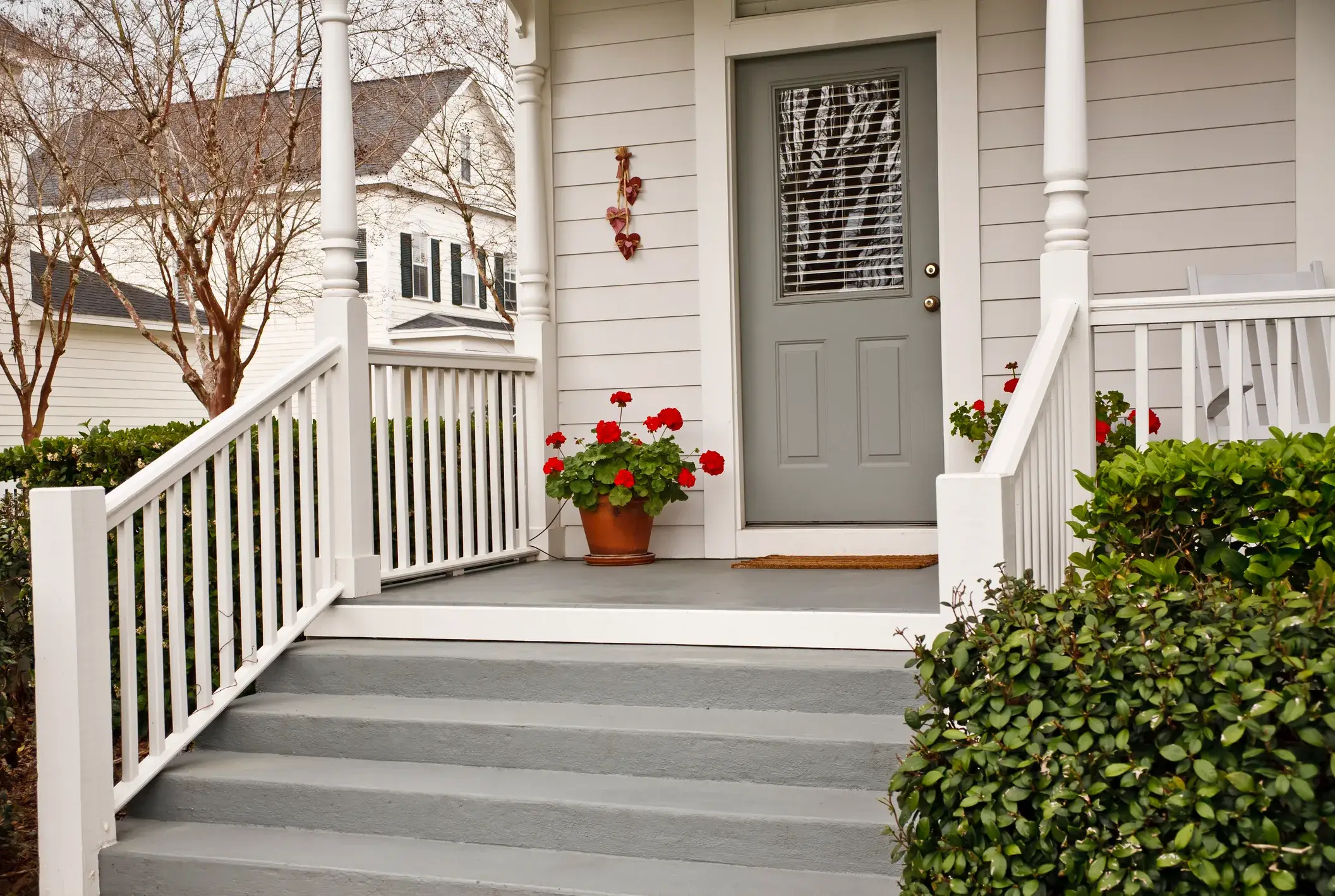 A white Colonial Georgian home with a gray front door