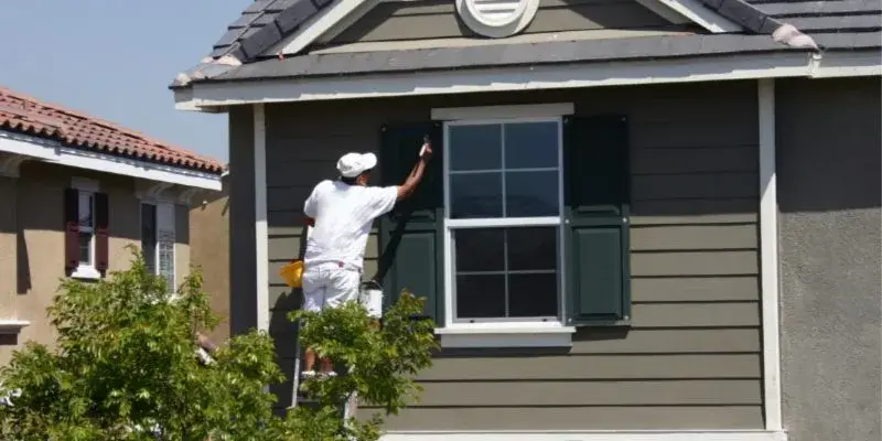 Exterior Painting Techniques - Kimberly Painting - Sandy Springs, GA - Painter on ladder painting shutters gray