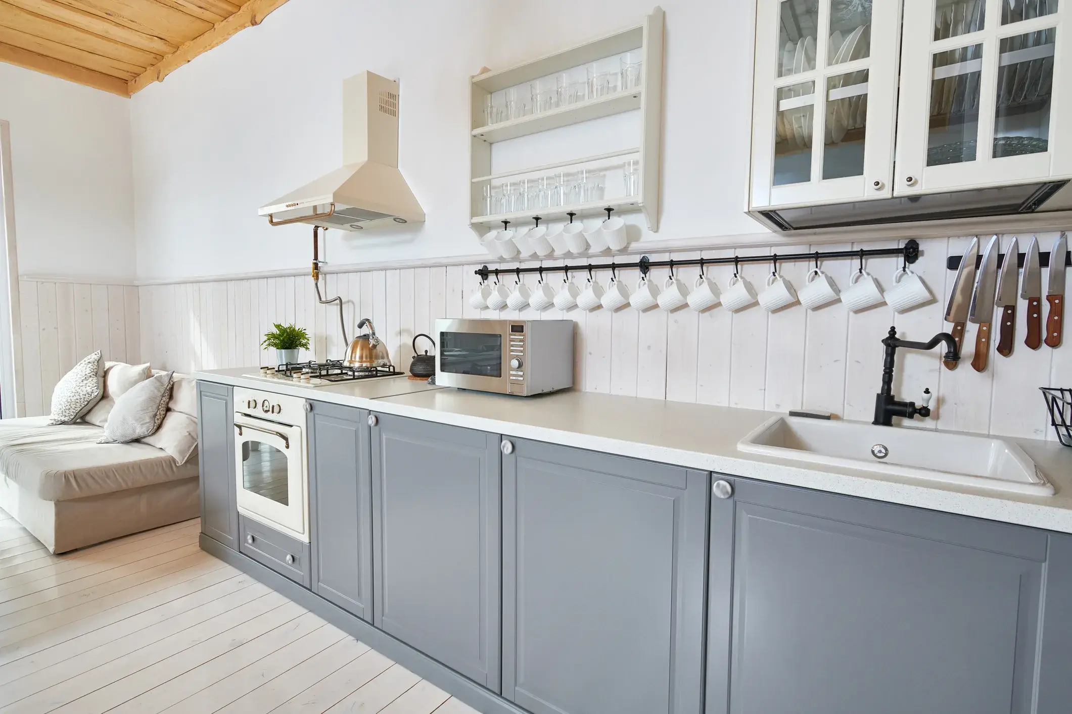 A kitchen with gray painted cabinets and white walls