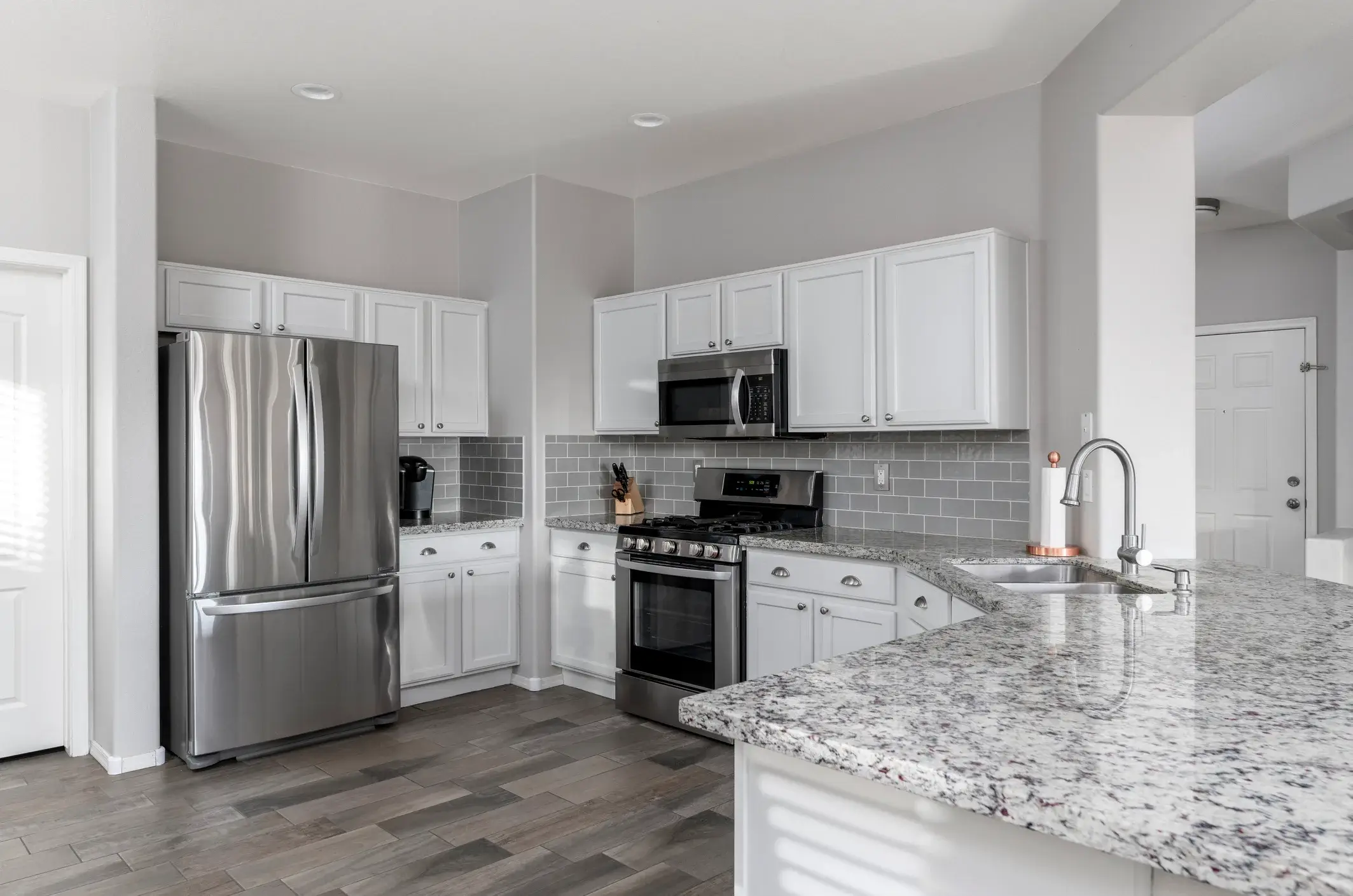 Light gray kitchen walls with white cabinets