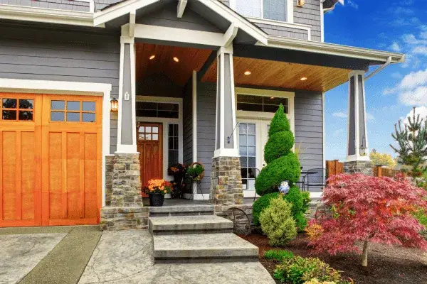 White and Dark Gray home with wooden accents and vibrant landscaping